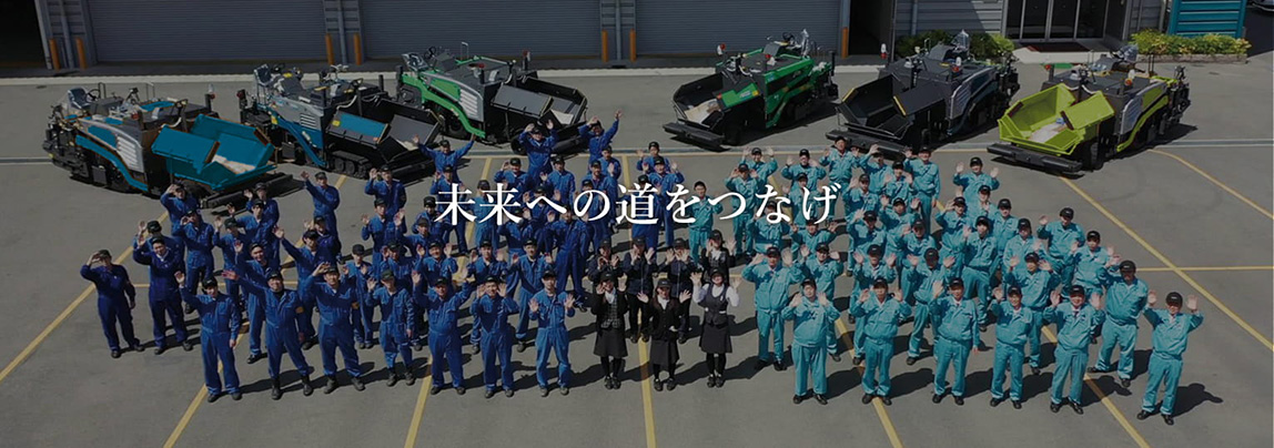 範多機械 社員集合写真とアスファルトフィニッシャー